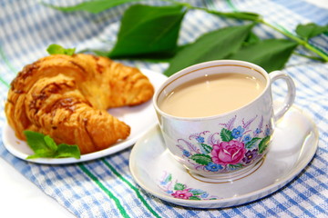 Cup of white coffee with croissant