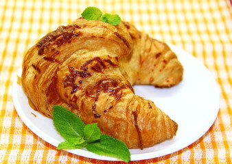 Croissant on the white plate with mint