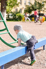Little boy tries to get on a children's ladder