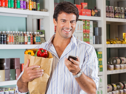 Man With Mobile Phone And Grocery Paper Bag