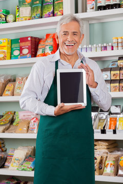 Male Owner Showing Digital Tablet In Store