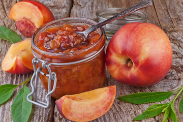 peach jam in a glass on old wooden table