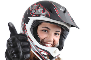 Happy biker woman with a motocross helmet and thumb up