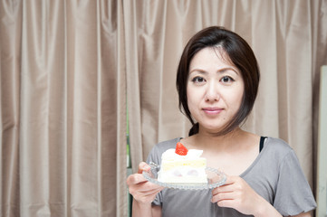 苺のケーキを持つ女性