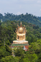 Golden Buddha statue surrounded by mountains