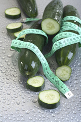.Concept of healthy eating - fresh cucumber and measuring tape