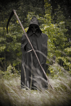 Death standing with scythe on hand