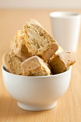 A bowl of rusks with coffee in the background
