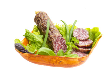 Ripe salami with salad, basil, onion and tomato