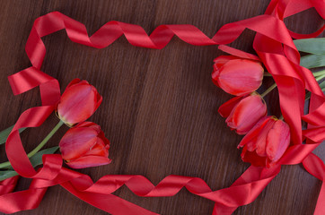 tulip on wooden background with red ribbon