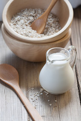 Wooden bowls and a small jug on the wooden background
