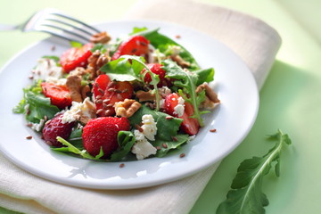 Salad with arugula, strawberries, goat cheese and walnuts