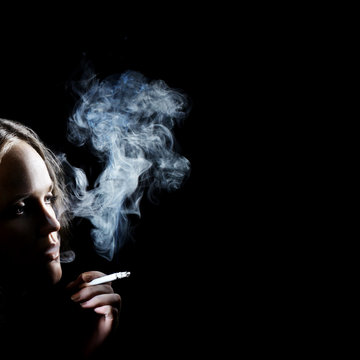 Smoking woman in darkness
