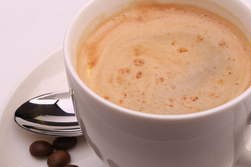 Cup of cappuccino and coffee beans