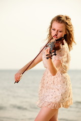 Fototapeta na wymiar The blonde girl with a violin outdoor