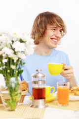 Young happy man drinking tea