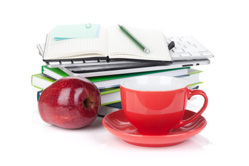 Red coffee cup, ripe apple and office supplies