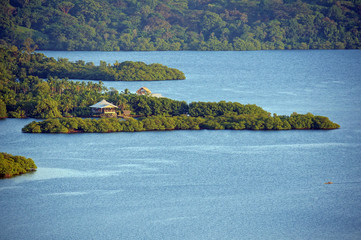 Aerial view of tropical coast with lush vegetation and a house, archipelago of Bocas del Toro,...