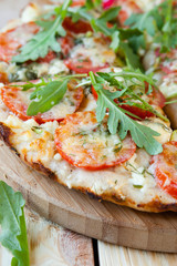 pizza with tomatoes, cheese and arugula