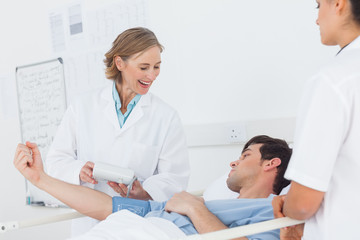 Fototapeta na wymiar Smiling doctor measuring blood pressure of a patient