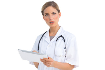 Puzzled nurse with tablet pc