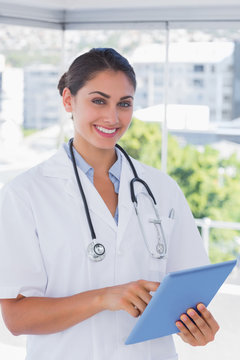 Smiling young doctor using tablet pc