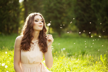 Beautiful woman blowing a dandelion