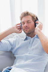 Man relaxing while listening to music on a couch