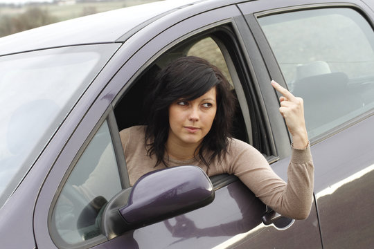 JEUNE FEMME ENERVEE AU VOLANT DE SA VOITURE