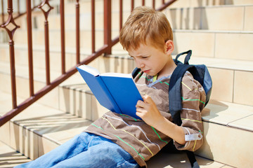 Young boy is reading book