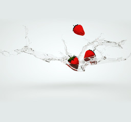 Strawberries falling into water