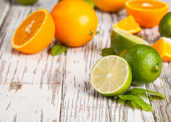 Fototapeta na wymiar Fresh limes and oranges on wood