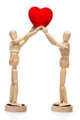 Two wooden dolls/ mannequins holding red heart, isolated