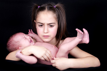 newborn baby crying held by her sister © dekanaryas