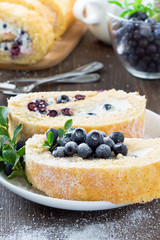 Sweet roll and a glass with fresh blueberry