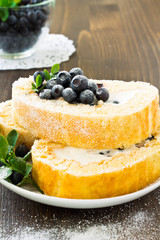 Sweet roll and a glass with fresh blueberry