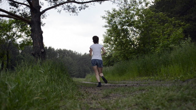 Young woman runs through forest and stops