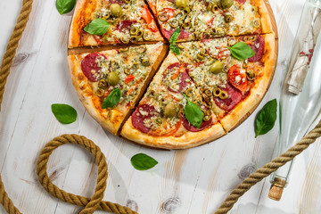 Pizza on a boat made of salami and olives