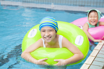 beautiful little girls with inflatable ring at swimming pool