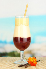Delicious fruit smoothie on table on blue background