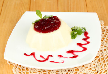 Panna Cotta with raspberry sauce, on wooden background