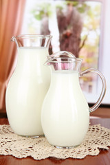 Pitchers of milk on table in room