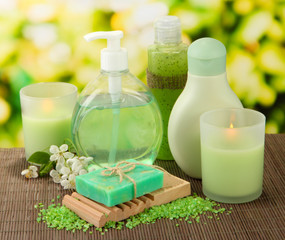 Obraz na płótnie Canvas Cosmetics bottles and natural handmade soap on green background