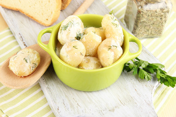 Tender young potatoes with sour cream and herbs in pan