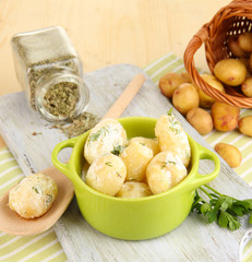 Tender young potatoes with sour cream and herbs in pan