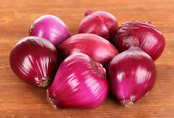 Purple onion on wooden background