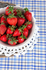 Strawberries in plate on wicker stand on napkin