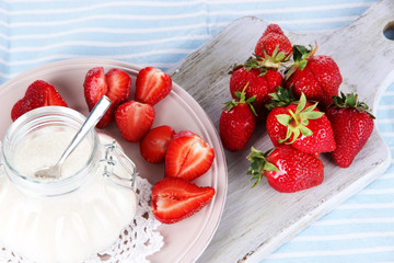 Strawberries on board cutting on striped napkin