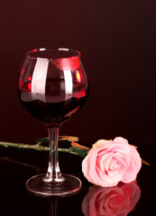 Glass of wine with lipstick imprint on dark background
