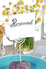 Table setting with chamomiles on checkered tablecloth close-up